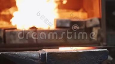 铁匠在铁砧上用大锤击铁棒.